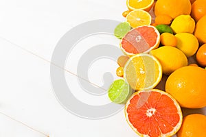Different citrus fruit on the white wooden table