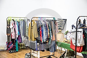 Different clothes and bags on the shelves and hangers