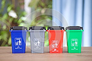 Different color classification trash bin models are arranged in a row