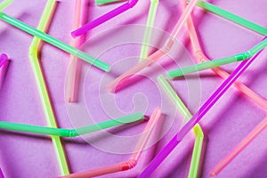 Different color cocktail tubes on pink