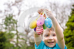 Different color Easter Eggs in a child`s hands- egg hunt