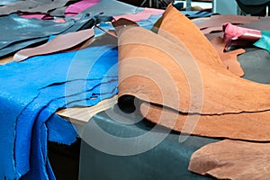 Different colored cowhides on table