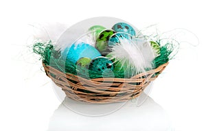 The different colored easter eggs in basket isolated on white.
