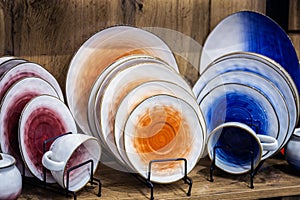 different-colored porcelain cups, plates and saucers are on the counter