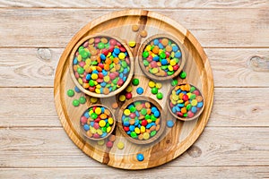 different colored round candy in bowl and jars. Top view of large variety sweets and candies with copy space