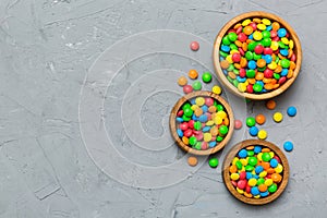 different colored round candy in bowl and jars. Top view of large variety sweets and candies with copy space