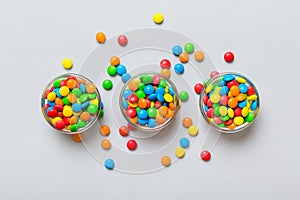 different colored round candy in bowl and jars. Top view of large variety sweets and candies with copy space