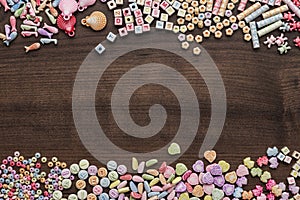 Different colorful beads on the brown wooden table