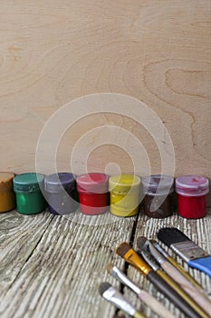 Different colorful brushes on the table, wooden background