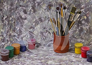 Different colorful brushes on the table, wooden background
