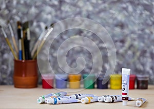 Different colorful brushes on the table, wooden background