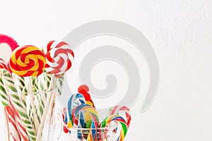 Different colorful candy sweets. Mix candy confectionery in jars on white wooden background with copy space