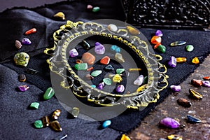 Different colorful gemstones in a frame on dark background. Stone therapy, spiritual healing, crystal energy, lithotherapy