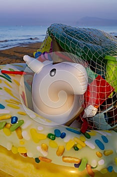 Different colorful kids beach toys stored on sandy beach for night