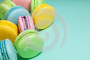 Different colorful macaroons on blue background. Free space for text