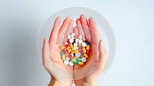 Different colorful medication pills and vitamins on female hands. Top view. Healthcare, pharmacy, medicine concept