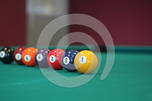 Different colorful numbered snooker balls placed in a line