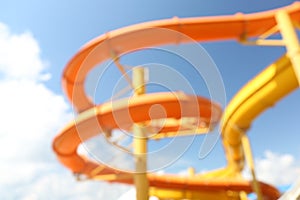 Different colorful slides in water park, blurred