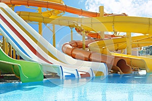 Different colorful slides in water park on day