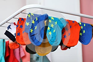 Different colorful socks on drying rack against blurred background