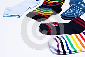 Different colorful textile clothes for legs, socks on white background with copy space. Selective focus