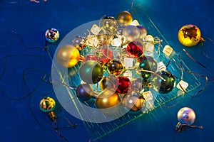 Different colors balls, lights are on the glass plate on the blue table/background. There are four ball with planet continents.