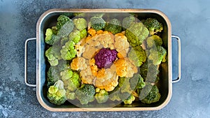 Different colourful cauliflower florets in baking dish before cooking Cabbage gratin. Concept healthy eating