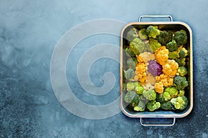 Different colourful cauliflower florets in baking dish before cooking Cabbage gratin. Concept healthy eating