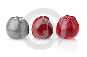 Different colourless apple with two red ones photo
