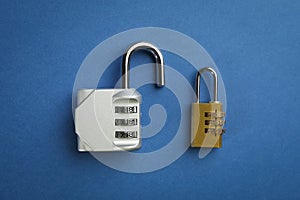 Different combination locks on blue background, flat lay