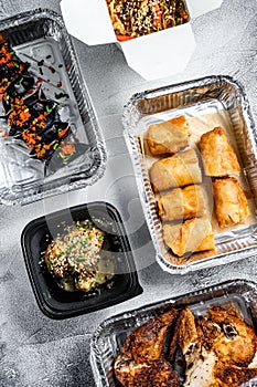 Different containers with delicious food. Delivery service. Asian cuisine, dumplings, spring rolls, dim sum, Peking duck. White