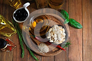 Different cooking oils and ingredients on wooden table, flat lay