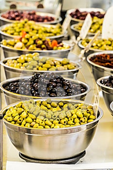 Different cured table olives in the bowls