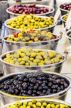 Different cured table olives in the bowls