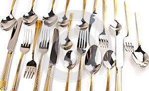 Different cutlery - forks, spoons and knives on a white background