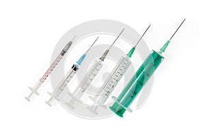 Different disposable syringes with needles on white background, top view