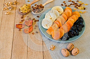 Different dried fruits on a plate on a wooden table