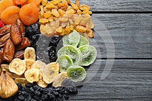 Different dried fruits on wooden background, top view with space for text.