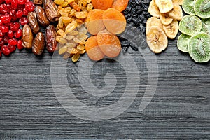 Different dried fruits on wooden background, top view with space for text.