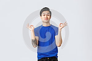 Different emotions, people lifestyle and advertising concept. Cheeky handsome queer guy, gay asian man in blue t-shirt