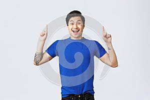 Different emotions, people lifestyle and advertising concept. Rejoicing, happy handsome asian man in blue t-shirt