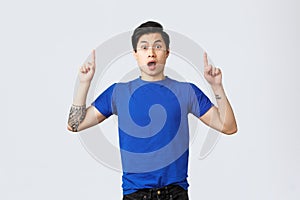 Different emotions, people lifestyle and advertising concept. Surprised and astonished asian male student, guy in blue t