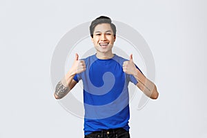 Different emotions, people lifestyle and advertising concept. Upbeat handsome asian man in blue t-shirt, being