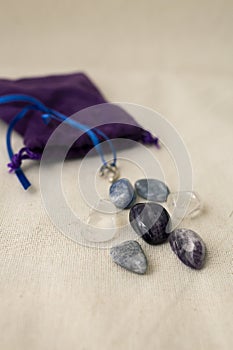 Different energy stones on a table next to your bag