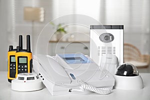 Different equipment for home security system on white table indoors