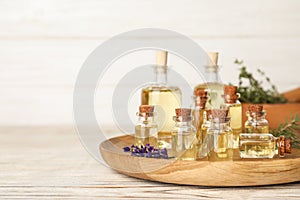 Different essential oils in glass bottles on table.