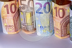 Different european bank notes illuminated as shiny bank note tubes with 50 euro, 20 euro, 10 euro and 5 euro