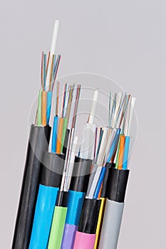 Different fiber optic cable ends with stripped jacket layers and exposed colored fibers