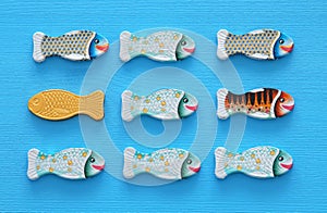 different fish swimming opposite way of identical ones. Courage and success concept.
