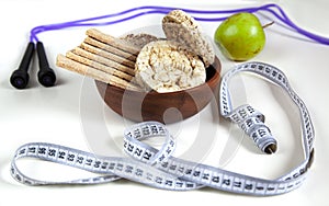 Different fitness equipment with apple and cereal crispbread